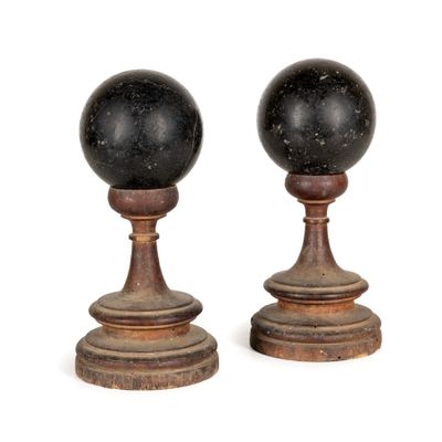 une paire de bougeoirs en marbre noir sur des socles en bois
