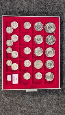 une boîte de pièces d'argent posée sur un sol recouvert de moquette