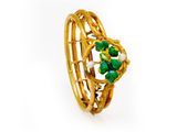 a close up of a gold ring with green stones