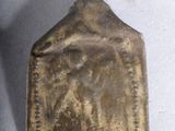 un petit objet métallique posé sur une surface blanche