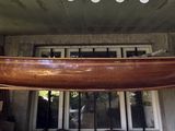 a large wooden boat hanging from the ceiling of a house