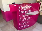 un comptoir rose et blanc sur lequel est accrochée une pancarte