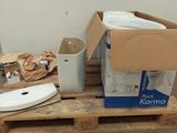 a white toilet sitting on a pallet next to a box of toilet paper