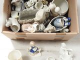 une boîte en carton remplie de petites figurines en céramique posée sur une table