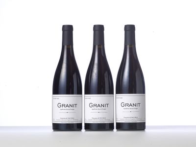 three bottles of red wine are lined up on a table