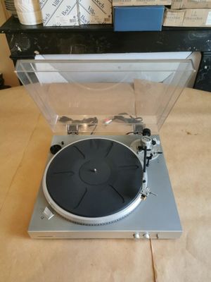 Le tourne-disque est posé sur une table en bois.