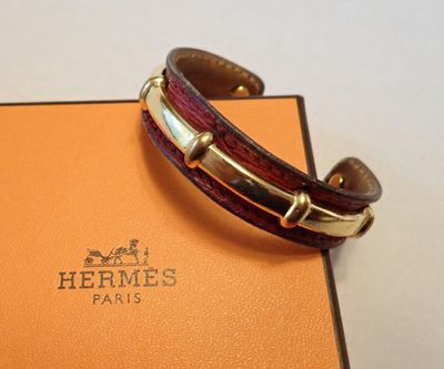 Le bracelet est en cuir et possède un fermoir plaqué or.