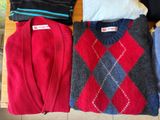 several sweaters are laid out on a table in a row