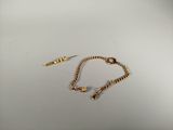 gold chain bracelet and earring on a white surface