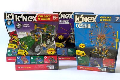 trois boîtes de jouets k ' nex avec une grande roue en arrière-plan