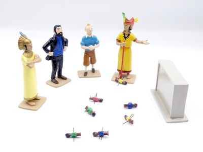 several toy figurines of people standing in a circle on a white surface