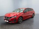 Une voiture rouge est garée dans une pièce au sol noir.
