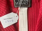 a close up of a red sweater with a tag on it