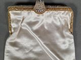 a close up of a white purse on a table