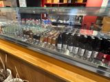 many bottles of alcohol on display behind a glass case