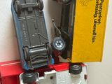 un camion miniature avec une voiture posée dessus, à côté d'une boîte