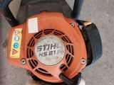 a small blower sitting on the ground next to a hose
