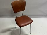 un fauteuil en cuir marron avec des pieds chromés et une assise en bois