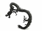 a black dragon sculpture on a white surface