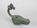 a green statue of a giraffe with a flower on it ' s head