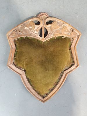 un vieux bouclier en bois recouvert de velours vert