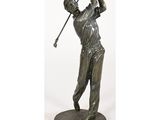 une statue représentant un homme brandissant un club de golf, posée sur un socle