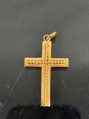 gros plan d'une croix en or sur une surface noire