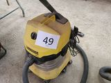 un aspirateur jaune posé par terre