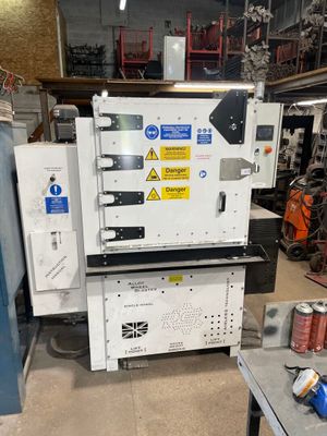 an image of a machine in a factory with cans of soda
