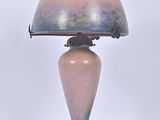 une lampe posée sur une table à côté d'un mur blanc