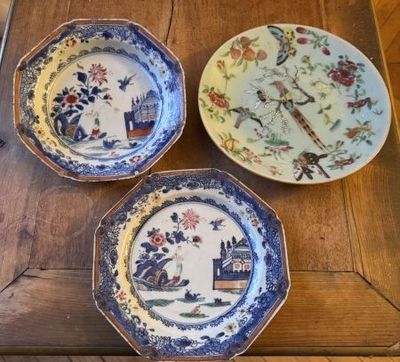 three plates with different designs on them sitting on a wooden table