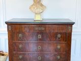 a wooden chest of drawers with a bust on top of it