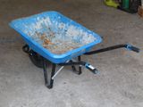 une brouette bleue dans un garage, avec une poignée noire