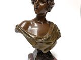 a bronze bust of a woman on a marble base