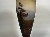a vase with a painting on it sitting on a table