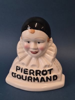 figurine en porcelaine représentant une femme coiffée d'un chapeau noir sur lequel est inscrit « Pierrot Gourmand »