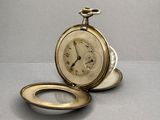 a gold pocket watch sitting on top of a silver plate