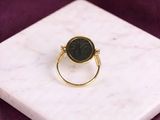 a close up of a gold ring with a black stone on it