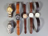 many different types of watches displayed on a table