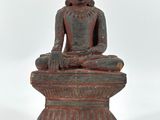 une image représentant une statue d'une personne assise sur un socle