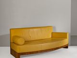 a yellow leather couch sitting in a white room