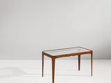 une table avec un plateau en verre posée sur un meuble blanc