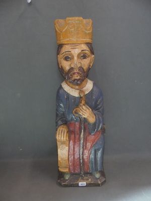une statue en bois représentant un homme coiffé d'un chapeau