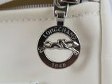 white purse with a silver logo on the front of it