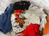 un panier rempli de vêtements posé sur un lit