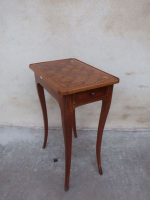 a small wooden table with a drawer on top of it