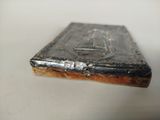 a silver book on a table with a white background