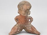 figurine représentant un homme assis, tenant une fleur dans une main et une autre fleur dans l'autre
