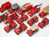 beaucoup de petits camions rouges en plastique sur une surface blanche