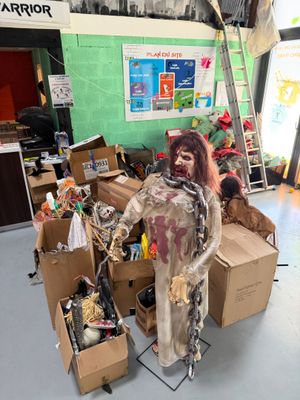 un faux zombie debout devant une pile de cartons